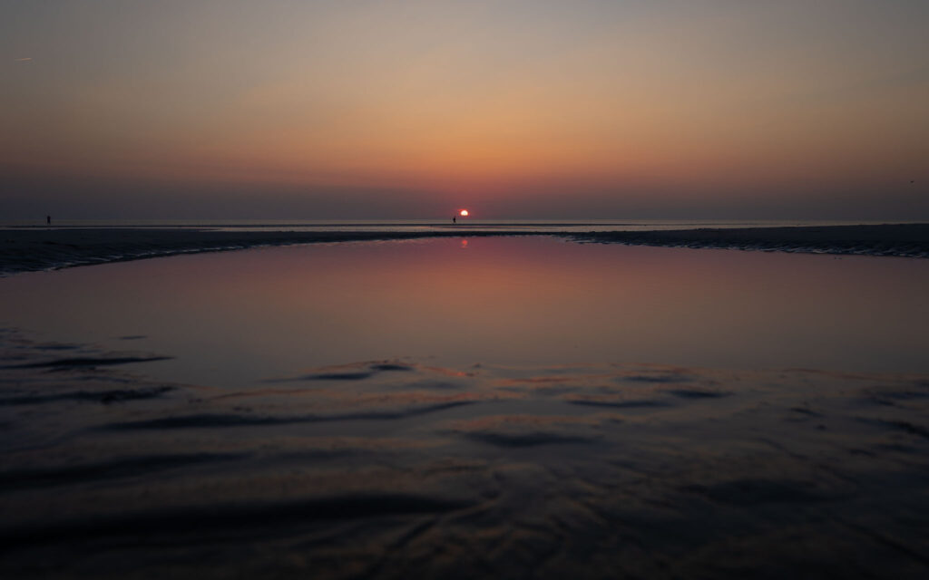 Sonnenuntergang mit Reflexion in Pfütze